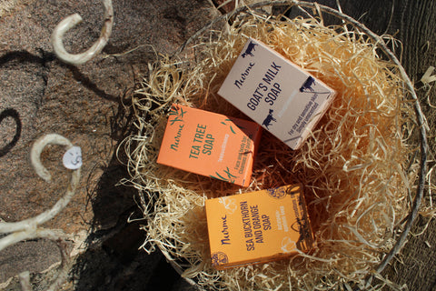 Various Nurme soap bars in colorful packaging, including options like Super Foaming Lemongrass, Sea Mineral, Pine Tar, Super Foaming Coconut, and Tea Tree Soap, arranged in a scattered layout.